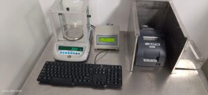 Analytical balance with data logger, thermal printer, and keyboard on stainless bench.